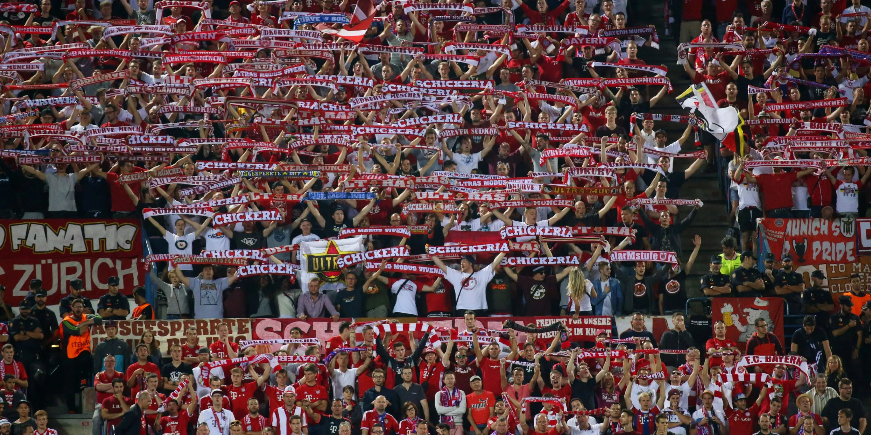 Cổ động viên Bayern Munich giơ cao khăn quàng cổ và hát